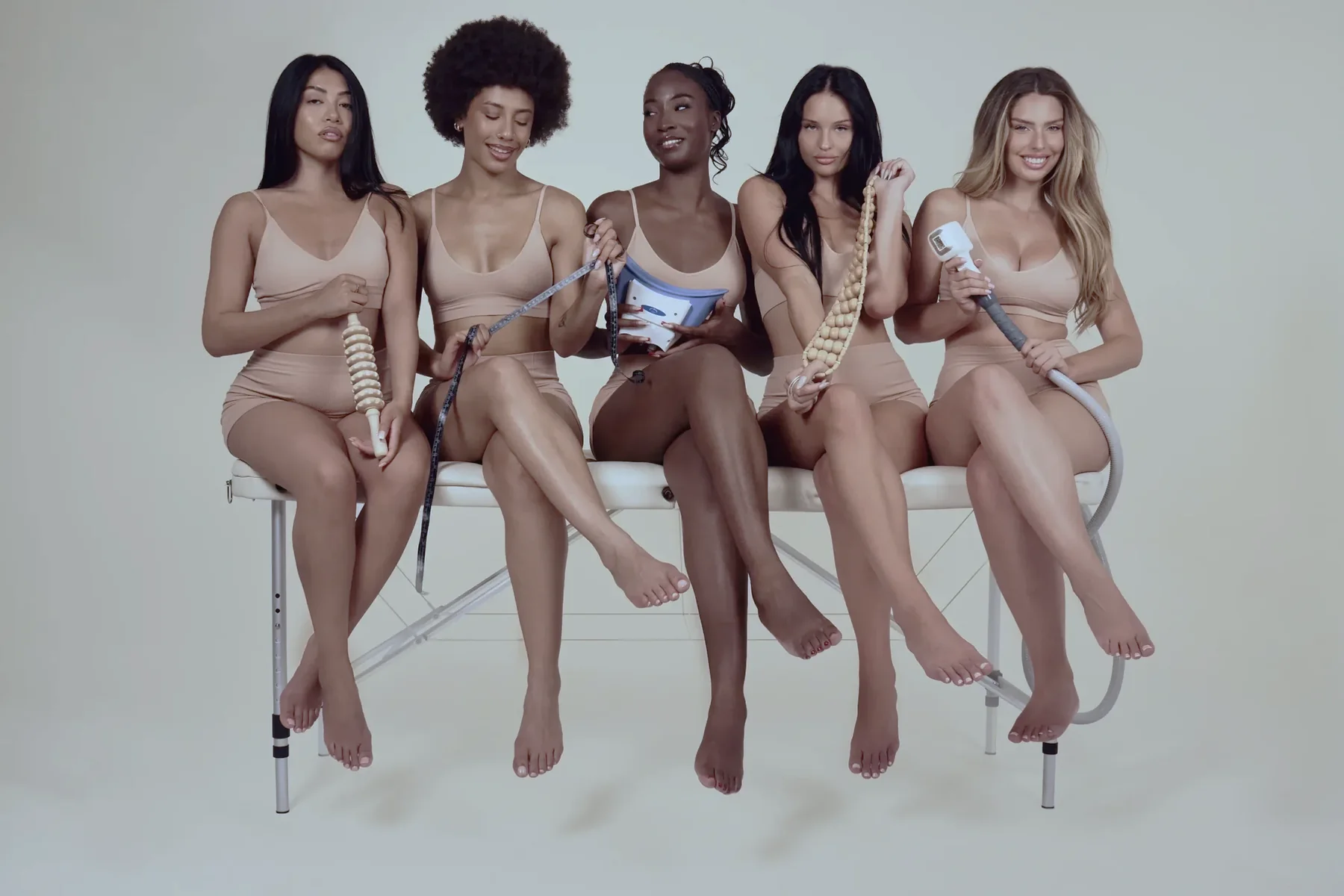 Cinq femmes assises sur une table de soin dans un studio Body Industry